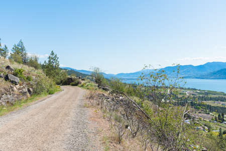 View of Kettle Valley Rail Trail high above village of Naramata and Okanagan Lakeの写真素材