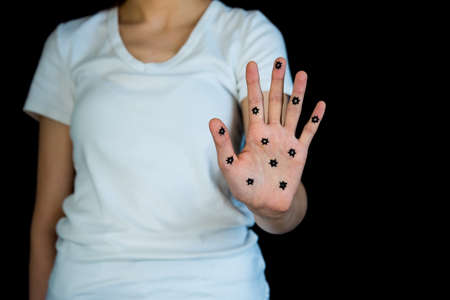 Concept photo of woman holding up hand contaminated with coronavirus COVID-19の写真素材