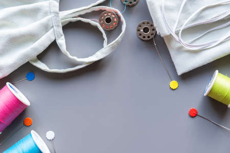 Fabric face mask and sewing supplies needed to sew a mask. Gray background with copy spaceの写真素材