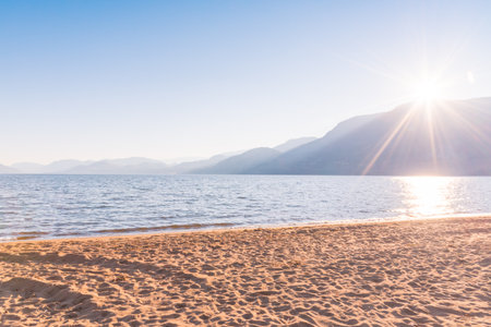 Skaha Lake and beach with blue sky and bright sunshine in autumnの写真素材