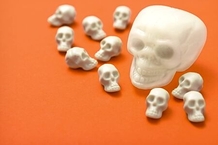 Halloween background, white skulls on the orange backgroundの写真素材