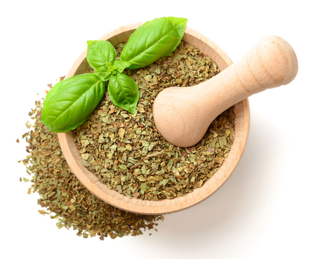 dried basil in the wooden mortar, isolated on white, top viewの写真素材