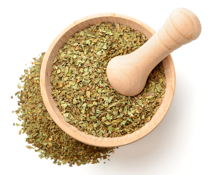 dried basil in the wooden mortar, isolated on white, top viewの写真素材
