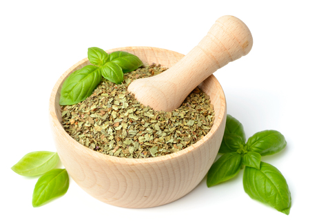 dried basil in the wooden mortar, isolated on whiteの写真素材