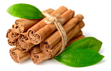 bunch of cinnamon sticks with fresh leaves isolated on the white backgroundの写真素材
