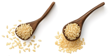 raw brown rice in the wooden spoon, isolated on the white background, top viewの写真素材