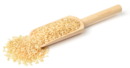 raw brown rice in the wooden scoop, isolated on the white backgroundの写真素材