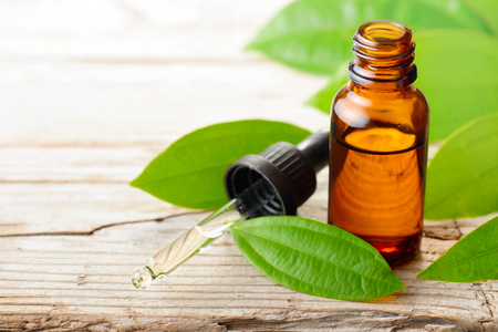 cinnamon oil and fresh cinnamon leaves on the wooden boardの写真素材