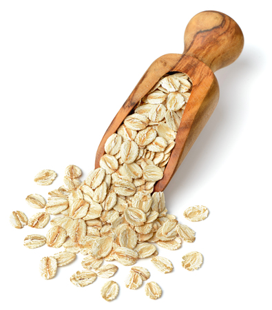 raw oatmeal in the wooden scoop, isolated on white backgroundの写真素材