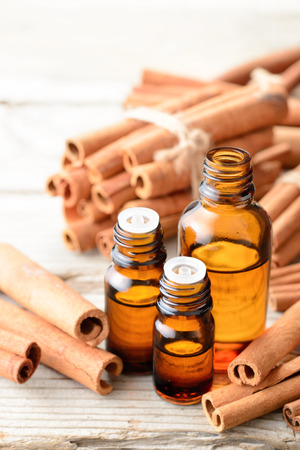 cinnamon oil and cinnamon sticks on the wooden tableの写真素材