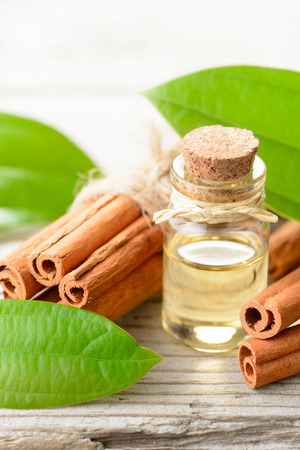 cinnamon oil in the glass bottle, on the wooden tableの写真素材