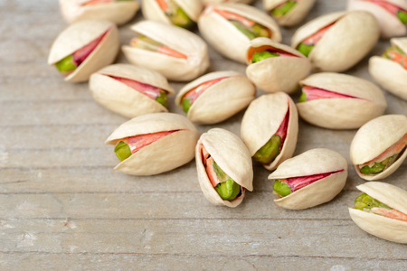 pistachio nuts with shell on the wooden boardの写真素材