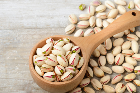 pistachio nuts with shell on the wooden boardの写真素材