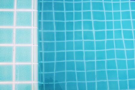 Rippled surface of Swimming pool blue water sun reflecting sleek backgroundの写真素材