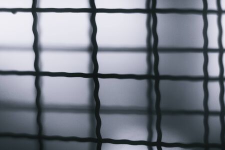 Blurred  Abstract Minimal style black and whith rays of sunlight cast shadows on the wire mesh steel metalの写真素材
