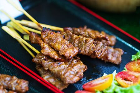 Close up of Grilled pork skewers sweet spicy sauce thai street food marketの写真素材
