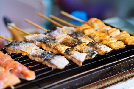 Close up of BBQ Grilled Salmon fish on wood stick thai street food marketの写真素材