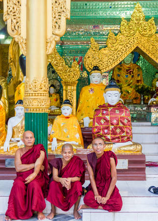 Yangon, Myanmar - November 3, 2013 - A group of buddhist monks take a rest in the court of Shwedagon Pagoda on November 3, 2013 in Yangon. Shwedagon Pagoda is the most famous and impressive buddhist temple in Myanmar. Its main Zedi is completely covered iのeditorial素材