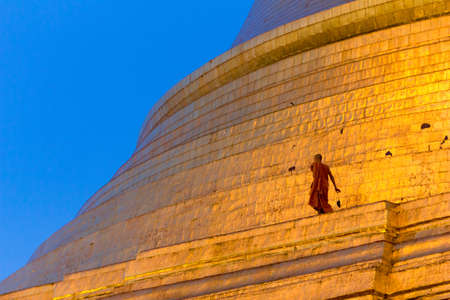 Yangon, Myanmar - November 3, 2013 - A buddhist monk collects dead rodents on the golden Zedi of Shwedagon Pagoda on November 3, 2013 in Yangon. Shwedagon Pagoda is the most famous and impressive buddhist temple in Myanmar. Its main Zedi is completely covのeditorial素材