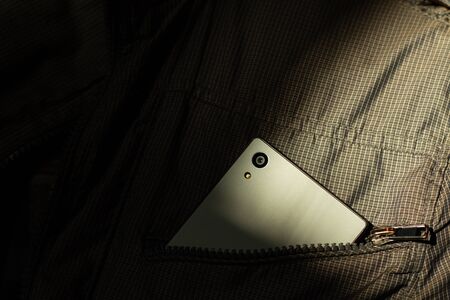 Modern smartphone in jacket pocket. Digital gadgets concept.の写真素材