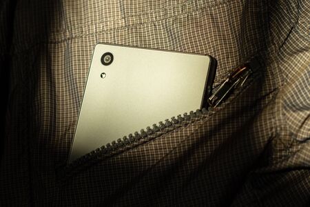 Modern smartphone in jacket pocket. Digital gadgets concept.の写真素材