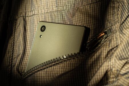 Modern smartphone in jacket pocket. Digital gadgets concept.の写真素材