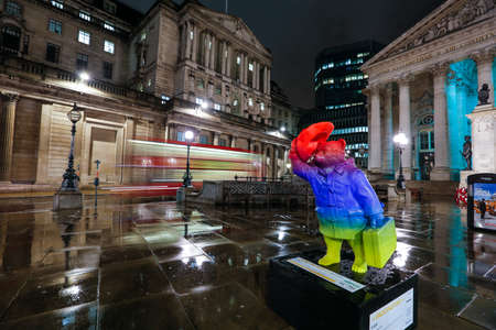 London, UK. Paddington Bear evening colorful statue near Bank station and with a Bank of England visible in the background with red bus のeditorial素材