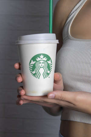 Badalona, Catalonia  Spain; JANUARY 10 2022: Girl holding a starbucks cup of coffee with logoのeditorial素材