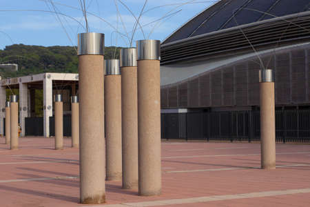 Barcelona, Catalonia  Spain; April 20 2021: Columns next to the Montjuic Communications Tower by Santiago Calatrava (1991) and street lamps in the Anella Olimpica.のeditorial素材