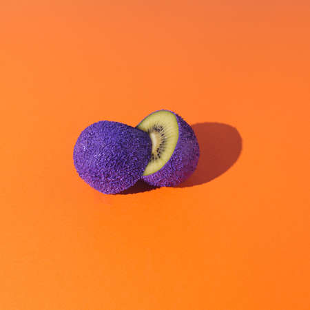 Fresh purple and green sliced segments  fruit kiwi  with orange backgroundの写真素材