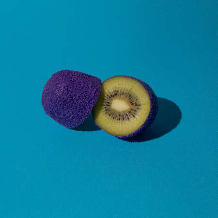 Fresh purple and green sliced segments  fruit kiwi  with blue backgroundの写真素材