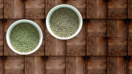 Two white bowls of dried hemp seeds on wooden backgroundの写真素材