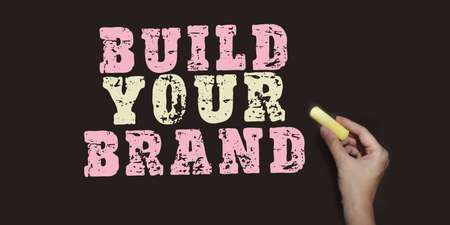 Concept image Build Your Brand written over blackboard with pink and yellow chalk, Branding marketing startup concept.の写真素材