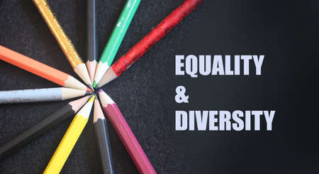 Clored pencils on a black background. Equality and diversity concept.