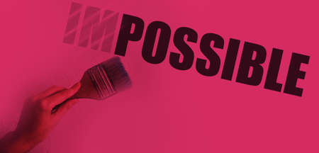 Impossible into possible word transforming with paintbrush in hand in magenta duotone. Challenging business startup concept.の写真素材