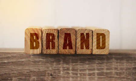Brand word letters on wooden blocks on old wooden table edge. Brand building for success business...