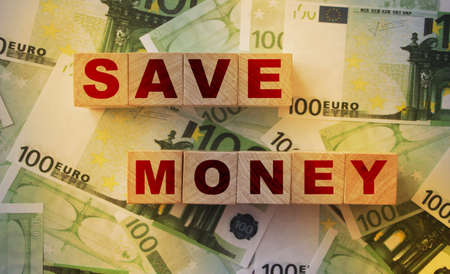 Save money word written on wooden block. Saving investment financial concept.の写真素材