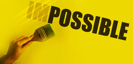 Impossible into possible word transforming with paintbrush in woman's hand . Motivation startup concept.の写真素材