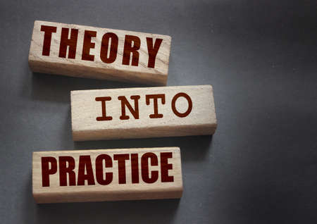 Theory into practice words written on wooden blocks. Education or business startup concept.の写真素材