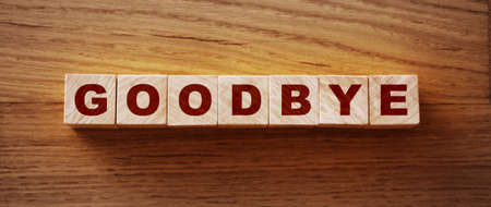 GOODBYE text on wooden cubes on a wooden background.の写真素材