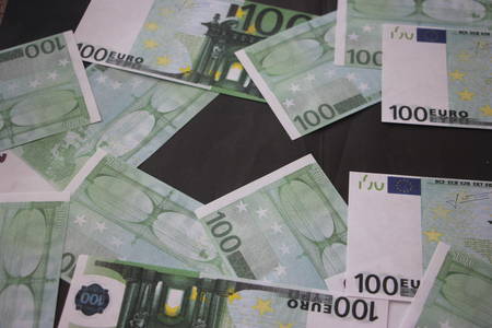 100 Euro banknotes laying flat on black background. Money concept.の写真素材