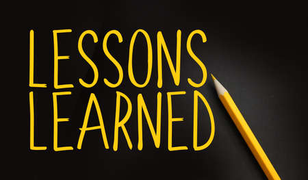 Lessons Learned text in yellow on black and pencil besides. Education or risk management in business concept.の写真素材