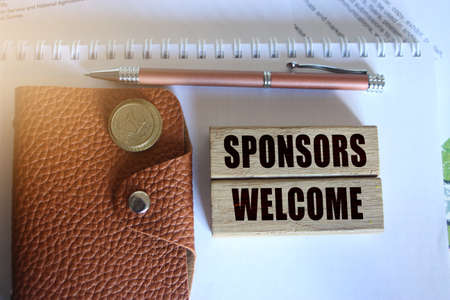 Sponsors welcome on wooden blocks, wallet pen and coins. Fundraising sponsorship concept .の写真素材