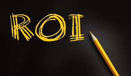 ROI text for Return on Investment yellow pencil on black. Business performance evaluation concept.の写真素材