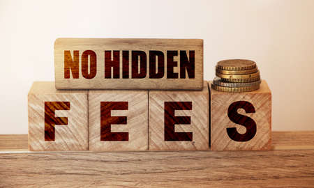 No hidden fees word written on wood blocks and pill of coins. Business agreement transparency and honesty concept.の写真素材