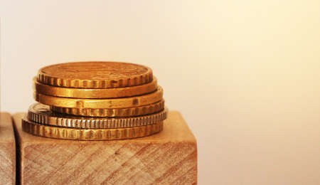 Stack of coins on wooden cubes with copyspace. Financial concept.の写真素材