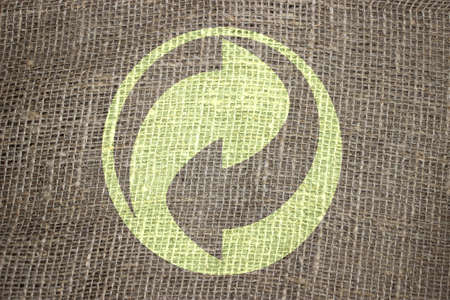 Recycle symbol on rough textile fabric. Concept of environment, recycling and eco awareness.の写真素材