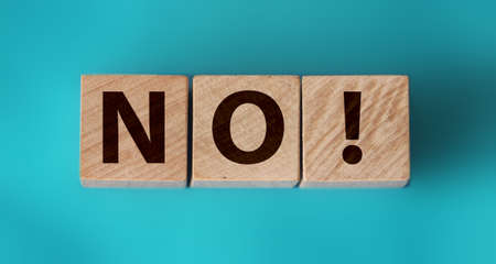 Wooden cubes with text no on a blue background. Negative answer concept. No risk, no violence or no discrimination concept.の写真素材