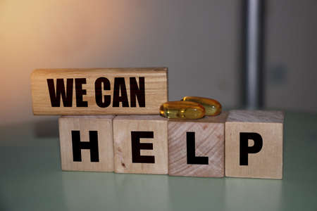 We can help - phrase on wooden blocks with letters, mutual assistance companionship concept.の写真素材