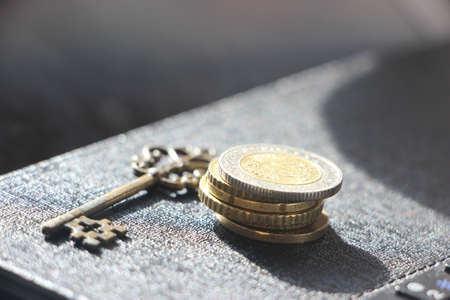 Vintage key and pile of coins. Money saving and Account Security Concept.の写真素材